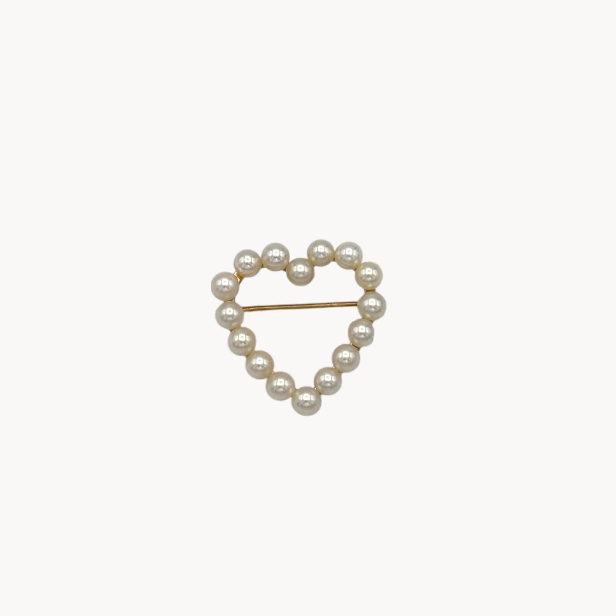 Close up view of Vintage 14K gold heart brooch with cultured pearls in a romantic design.