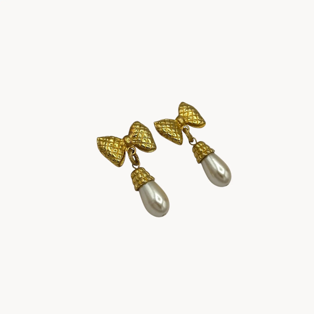 Side view of Vintage 1980s gold bow earrings with faux pearl drops, unsigned pierced bridal jewelry.