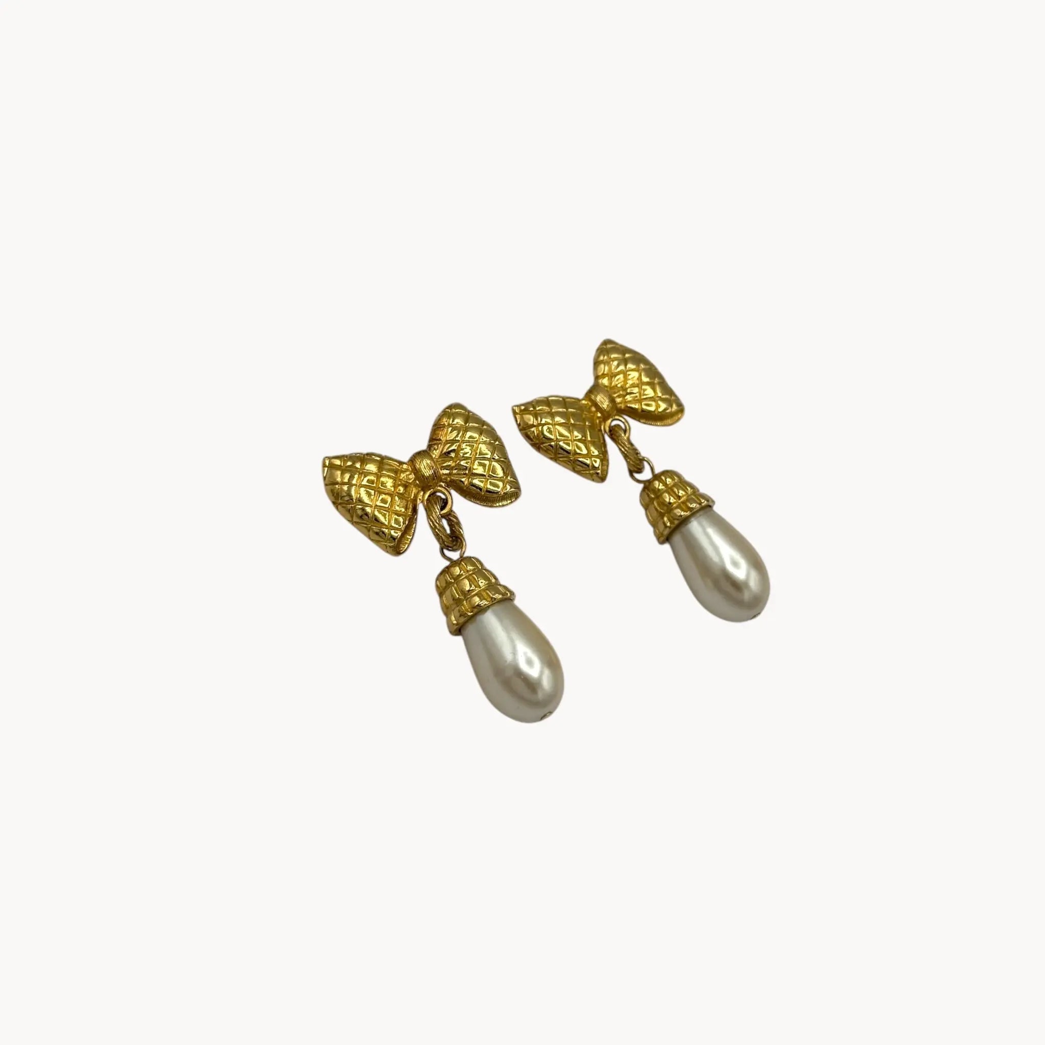 Side view of Vintage 1980s gold bow earrings with faux pearl drops, unsigned pierced bridal jewelry.