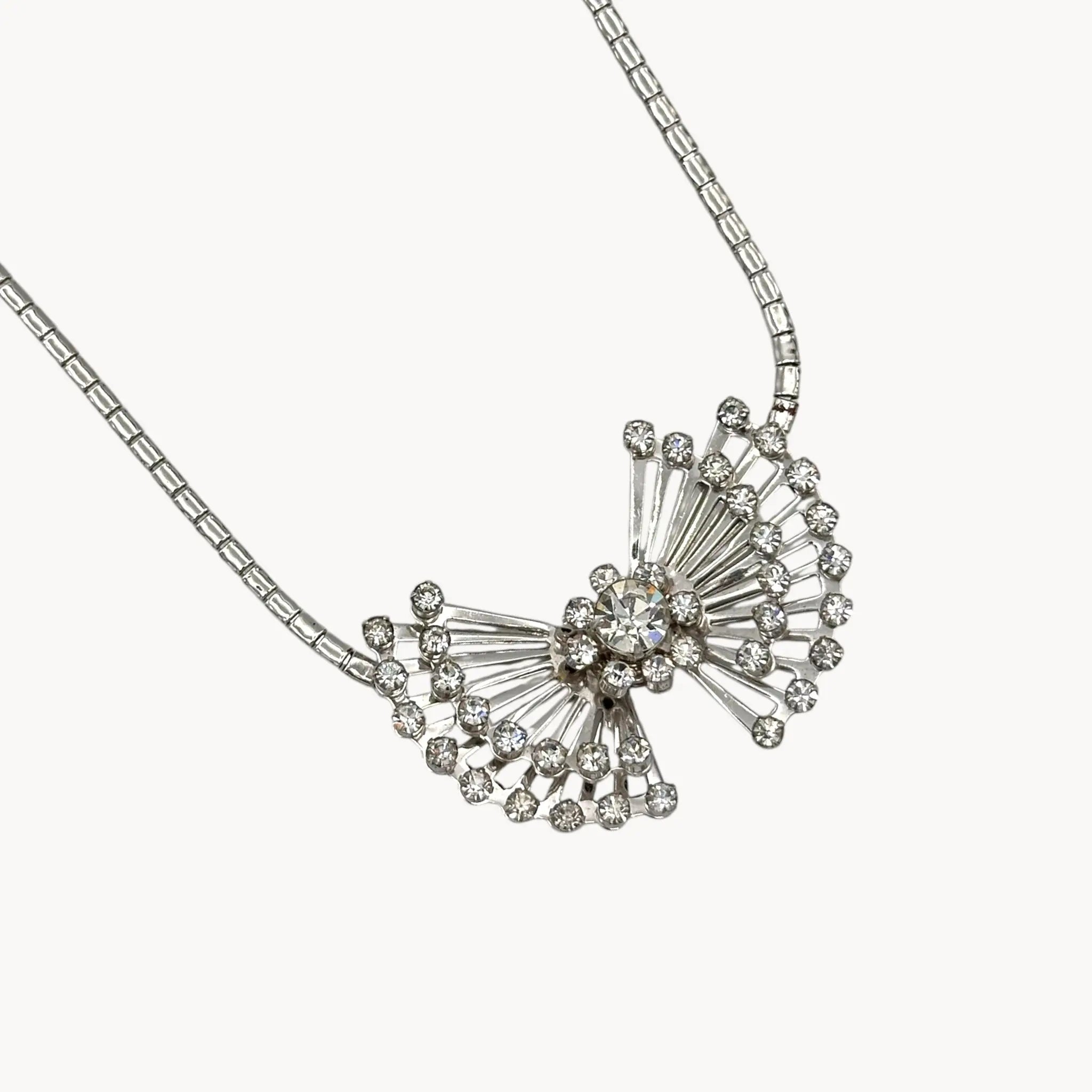 Close up view of pendant on Vintage 1950s silver plated rhinestone necklace with statement bow design, mid-century bridal jewelry.