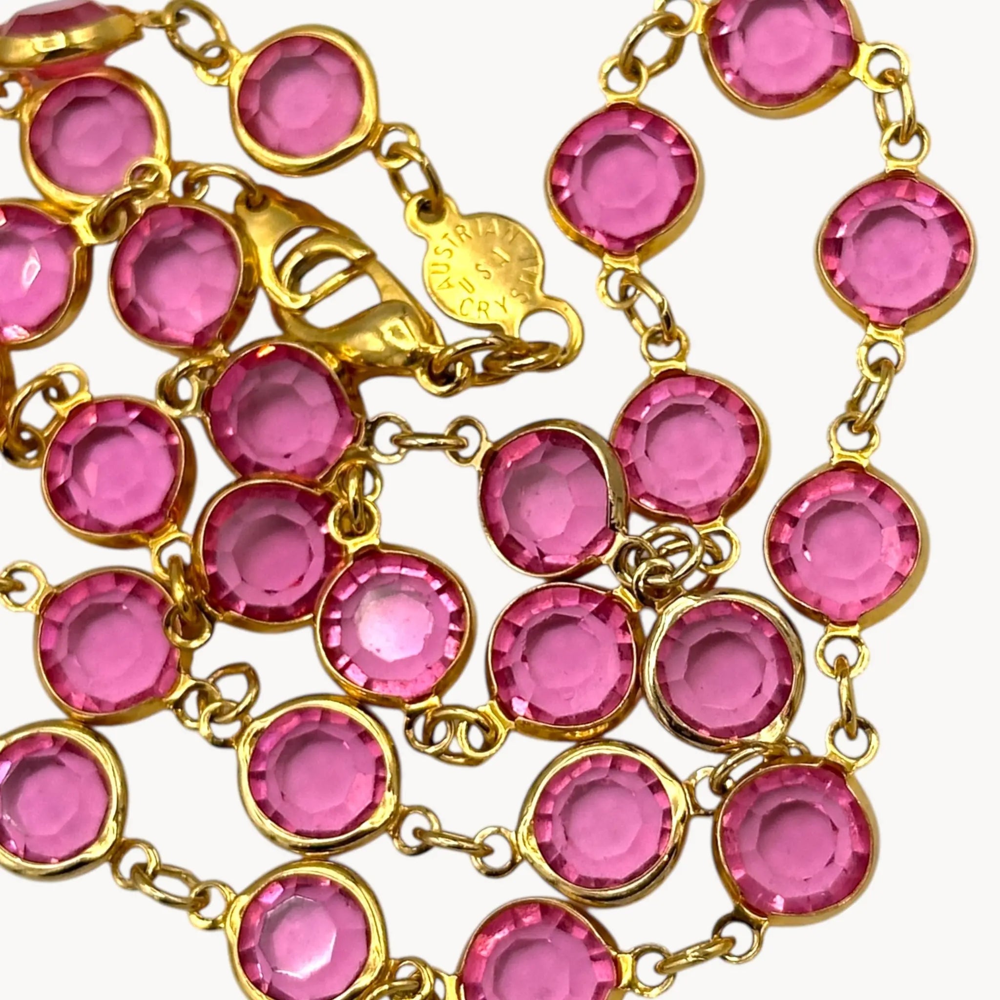 Close up Vintage Austrian pink crystal bezel-set long necklace with gold-tone chain, 1970s–1980s bridal or evening jewelry.
