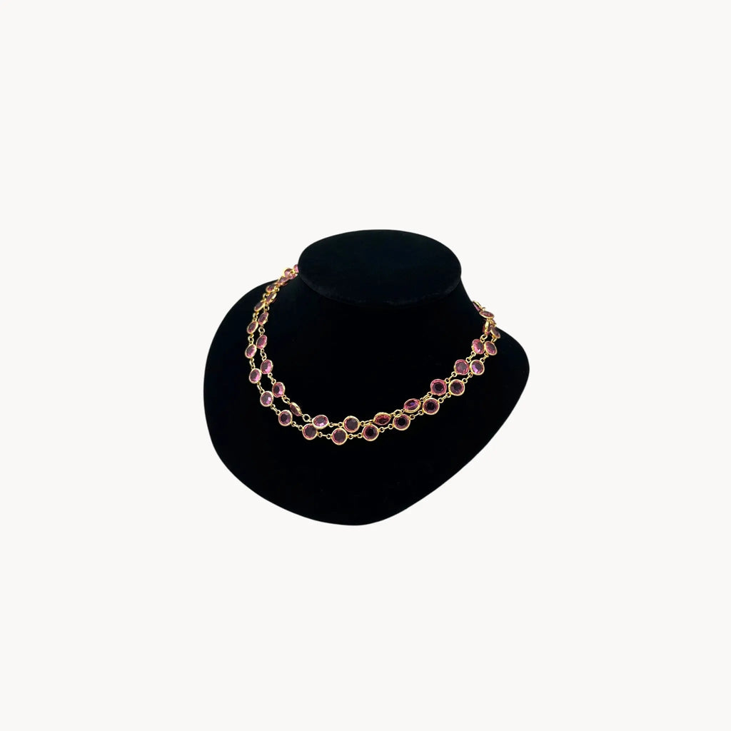 Close up view of Vintage Austrian pink crystal bezel-set long necklace with gold-tone chain, 1970s–1980s bridal or evening jewelry should doubled on black bust.