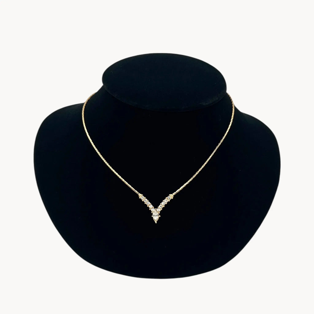 Close up Vintage Christian Dior necklace with gold-tone chain and V-shaped crystal pendant, 1990s bridal jewelry.