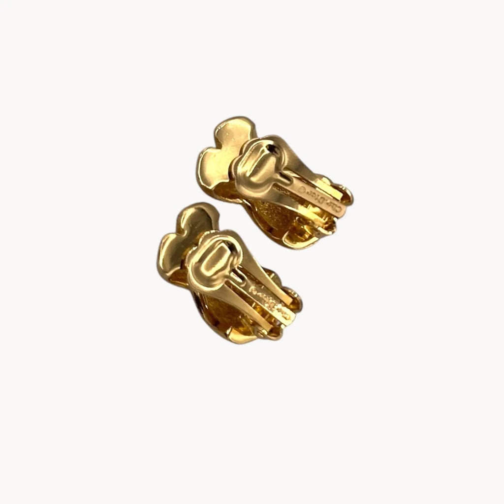 Close up back view of Vintage Christian Dior petite gold-tone clip-on earrings with rhinestone ribbon detail.