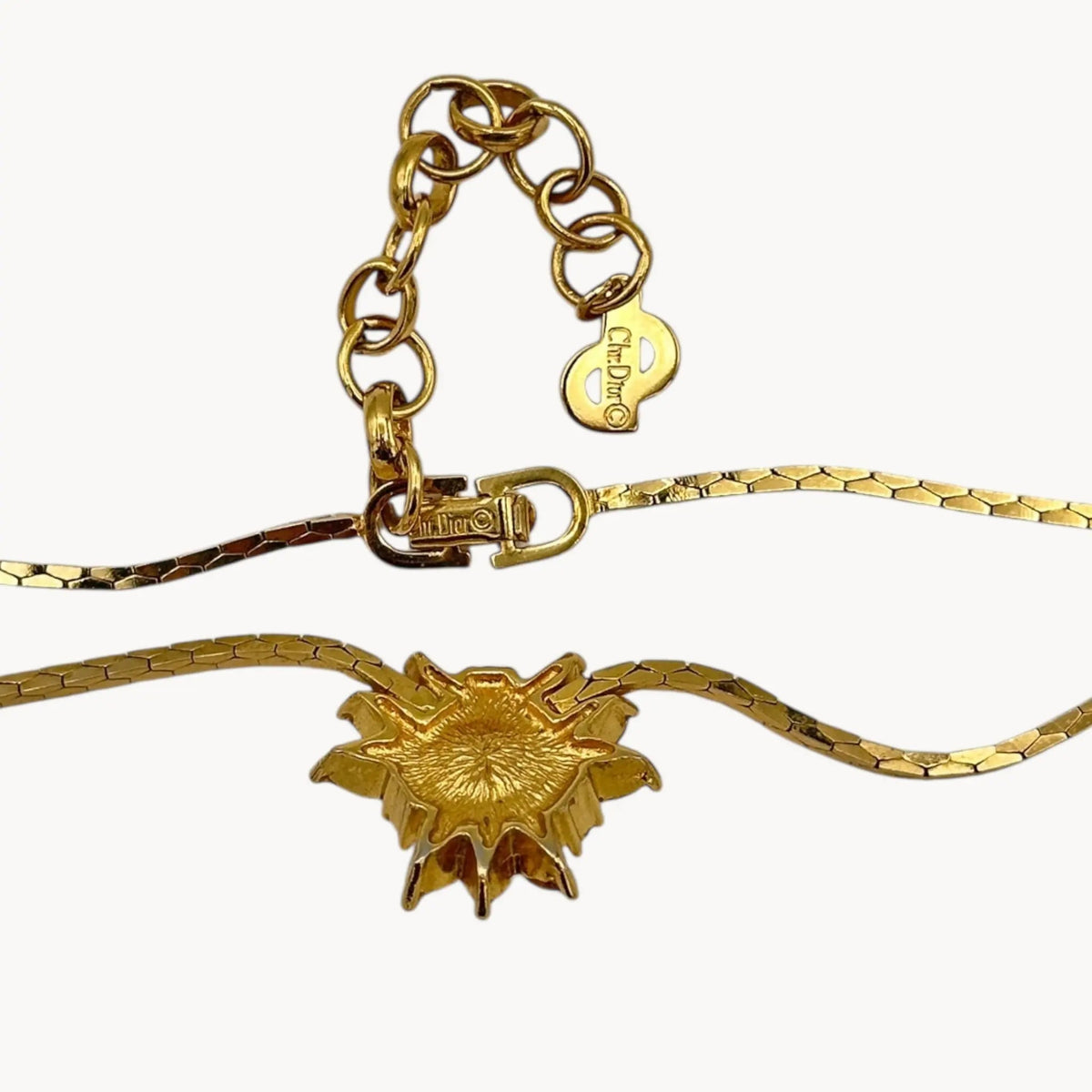 Back view Vintage Christian Dior necklace with gold-tone chain and starburst pendant featuring pearl center and crystal accents, 1980s bridal jewelry.