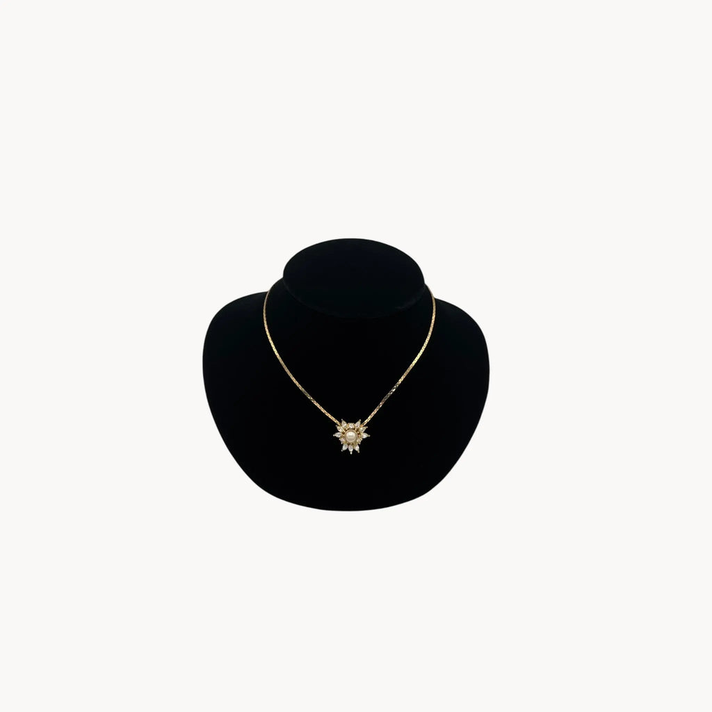 Vintage Christian Dior necklace with gold-tone chain and starburst pendant featuring pearl center and crystal accents, 1980s bridal jewelry.