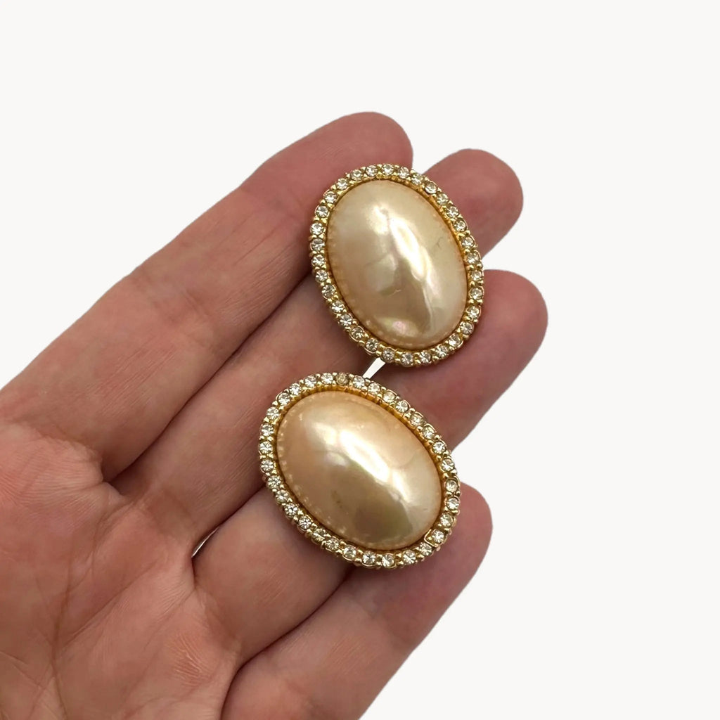 Scale size view of Vintage Ciner faux pearl clip-on earrings with rhinestone halo