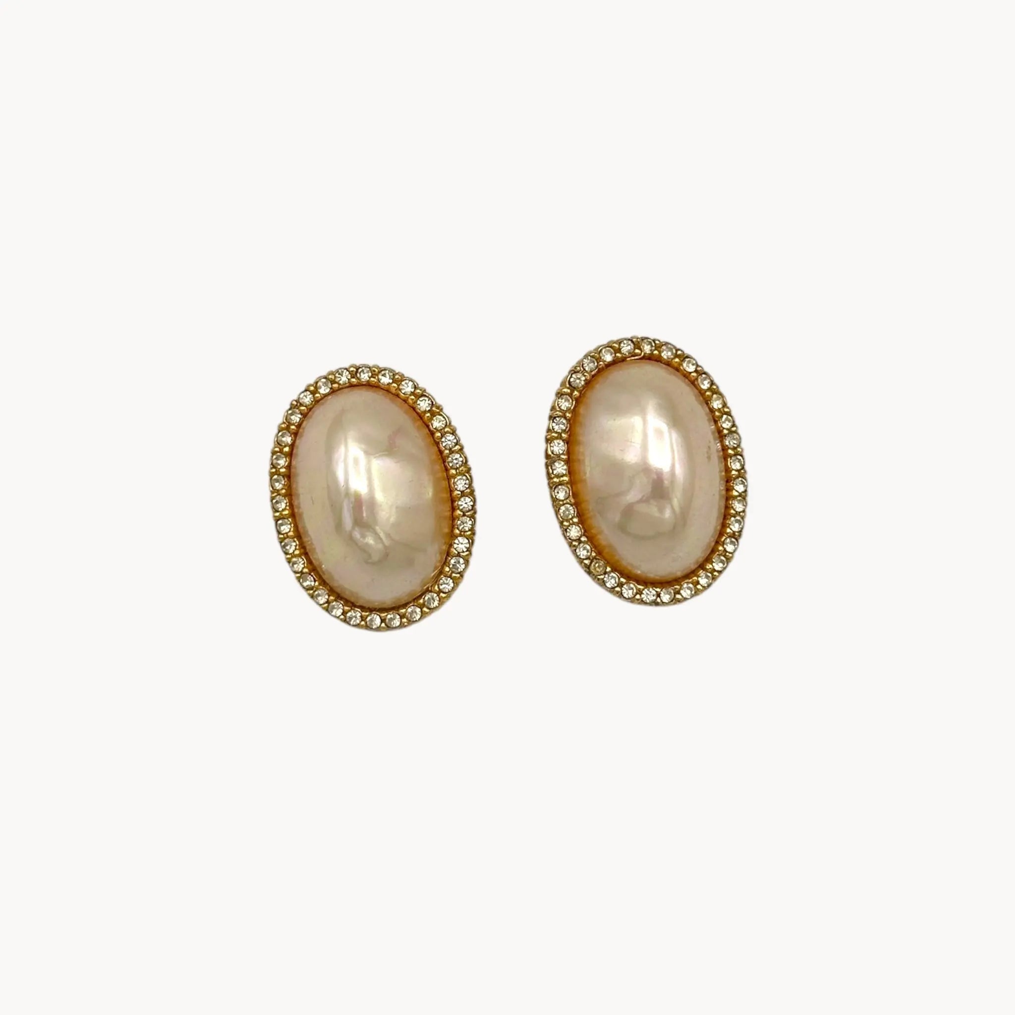 Close up view of Vintage Ciner faux pearl clip-on earrings with rhinestone halo