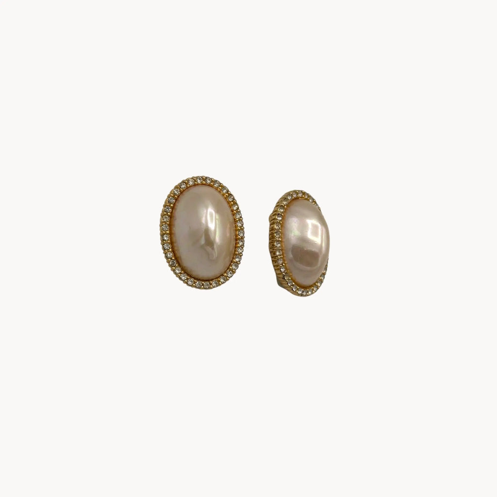 Side view of Vintage Ciner faux pearl clip-on earrings with rhinestone halo