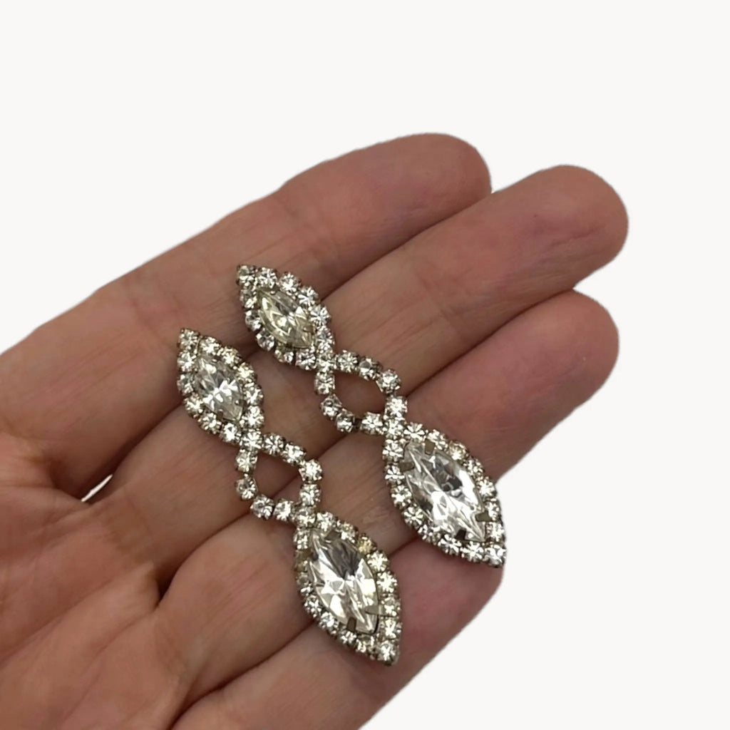 Scale view on hand of Vintage clear rhinestone dangle pierced earrings with marquise stones, bridal jewelry.