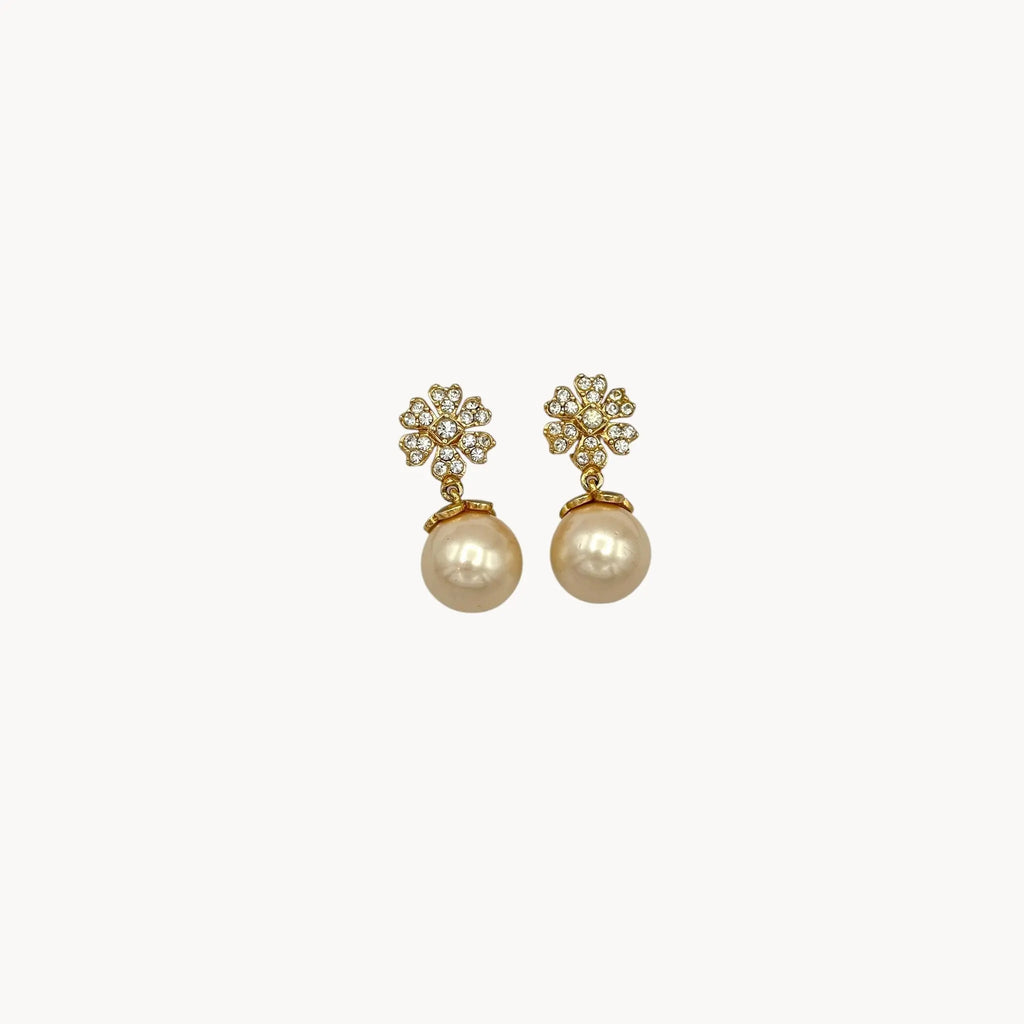 Close up Vintage unmarked clip-on earrings with crystal floral tops and faux pearl drops, 1990s bridal jewelry.