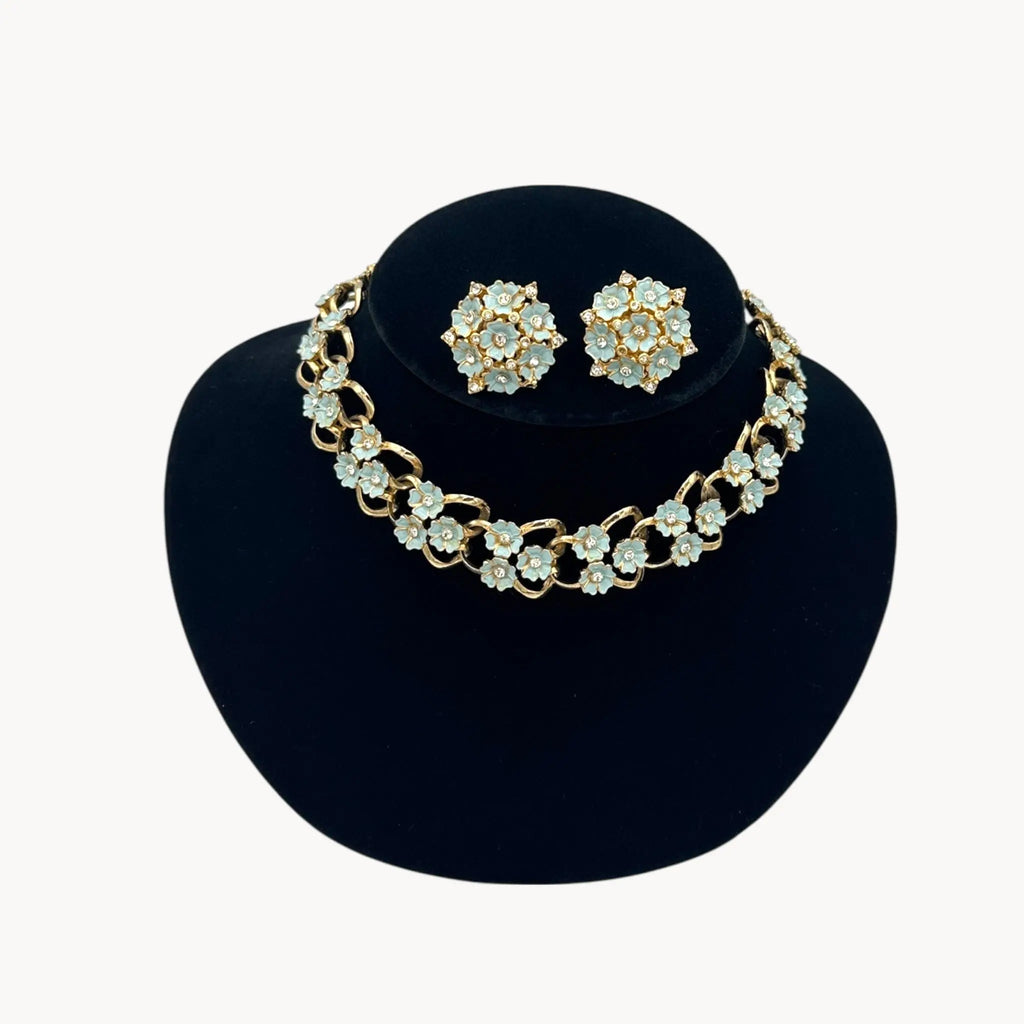 Close up view of Vintage mid-century forget-me-not floral necklace and earring set with blue enamel flowers and rhinestones, 1950s bridal jewelry.