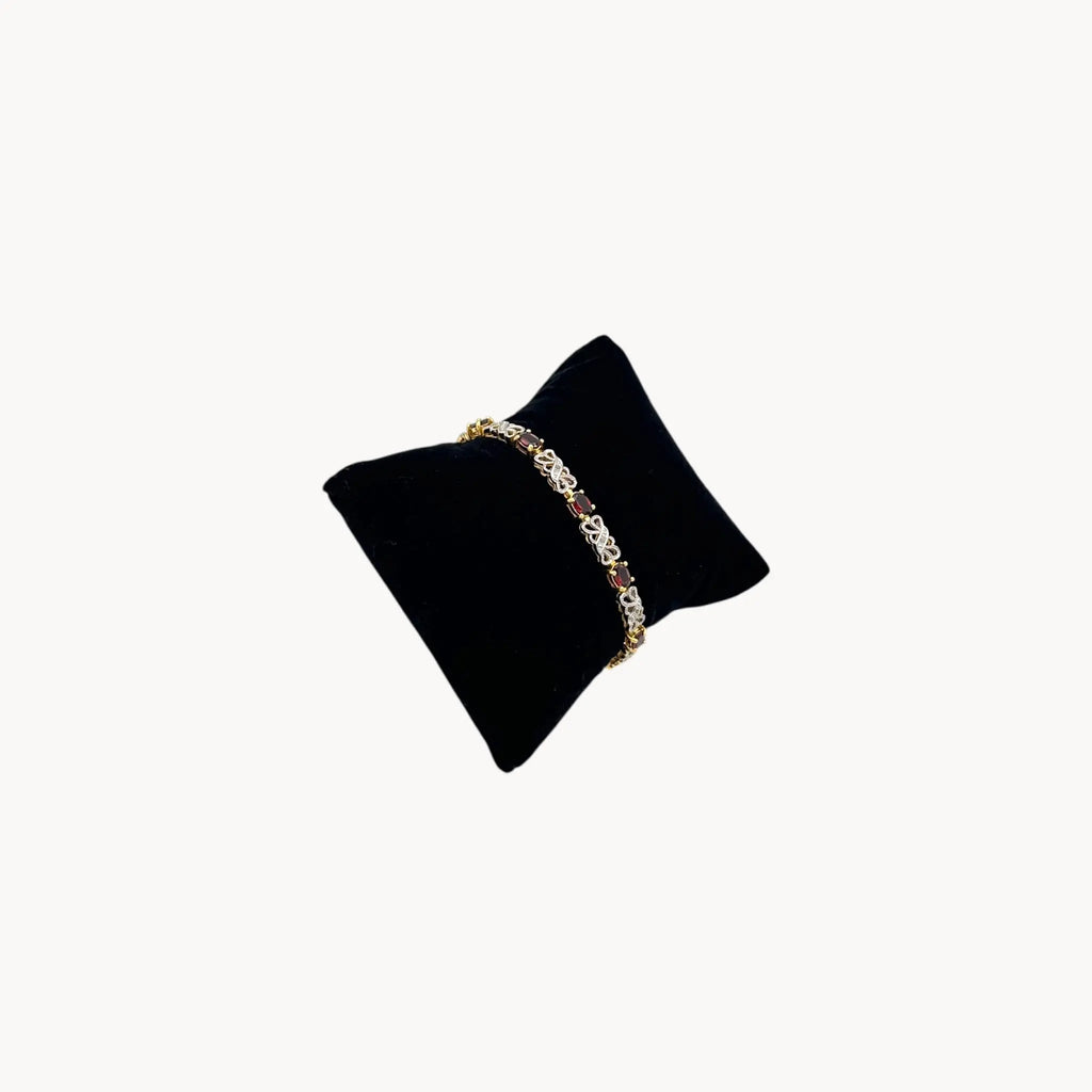 Side view of Sterling silver garnet tennis bracelet with oval red stones and filigree links, vintage bridal and evening jewelry.