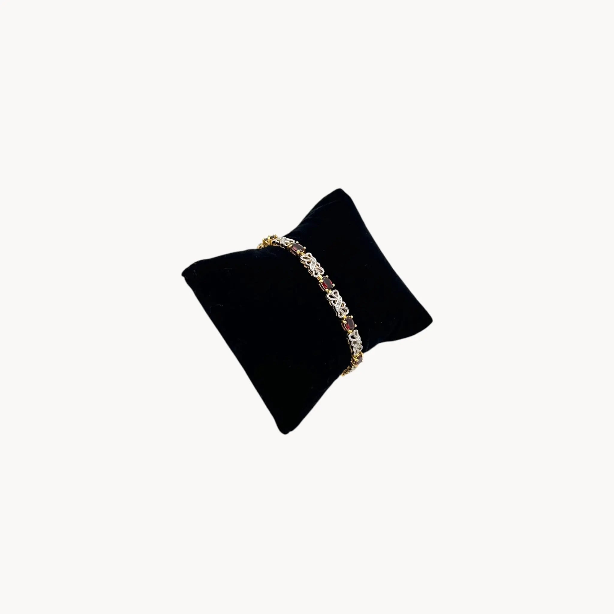 Side view of Sterling silver garnet tennis bracelet with oval red stones and filigree links, vintage bridal and evening jewelry.