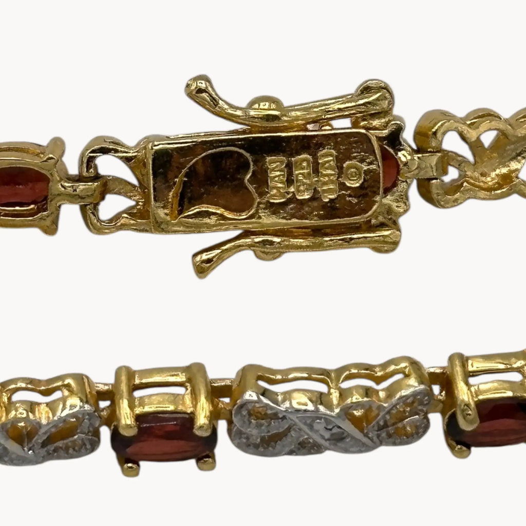 Close up of clasp view Sterling silver garnet tennis bracelet with oval red stones and filigree links, vintage bridal and evening jewelry.