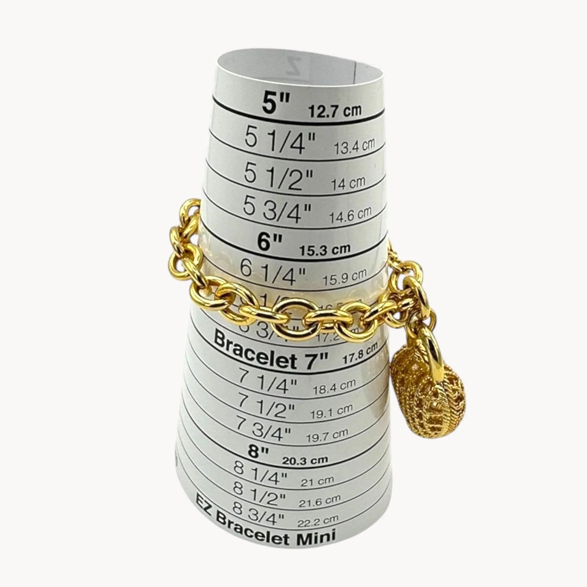 Bracelet on sizer of Bracelet of Vintage gold caged pearl heart bracelet and matching clip-on earrings set, 1980s–1990s jewelry on white background.