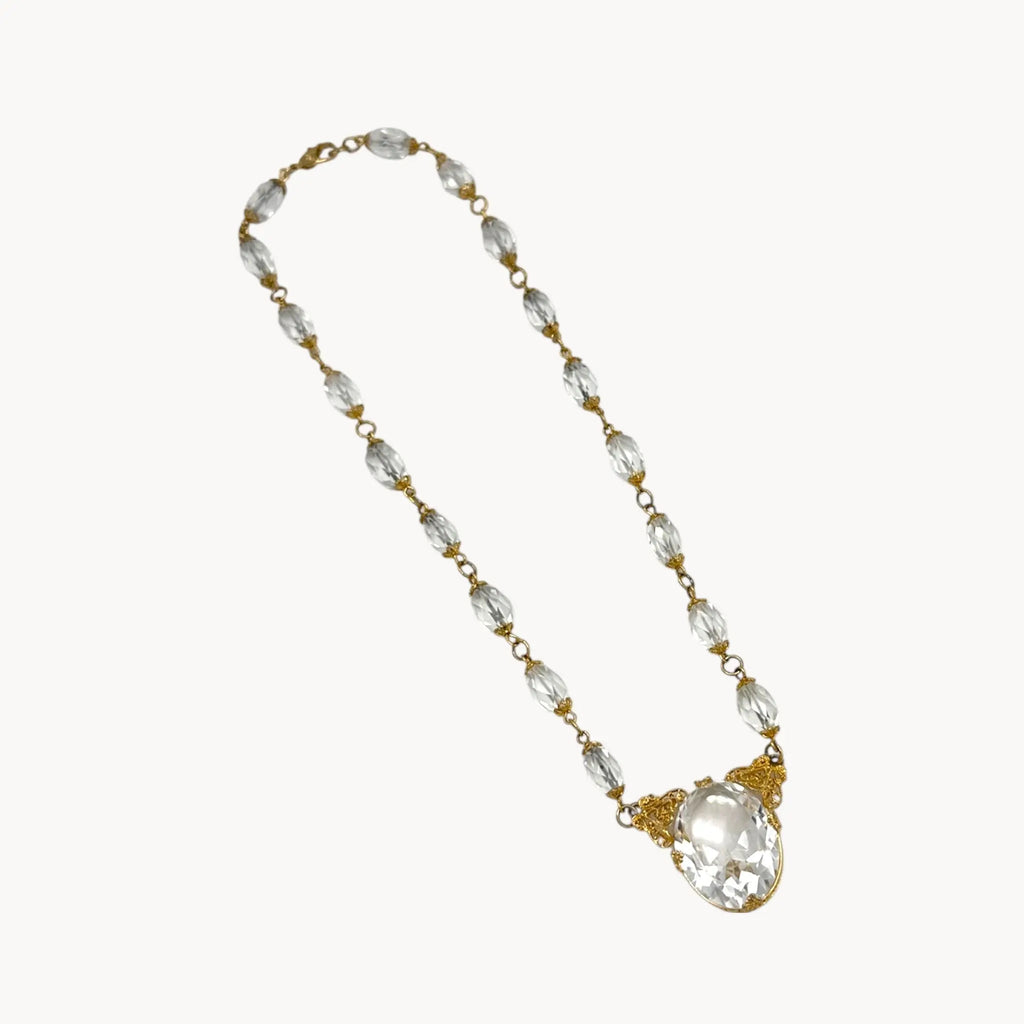 Necklace with clear beads and a large crystal pendant on a white background
