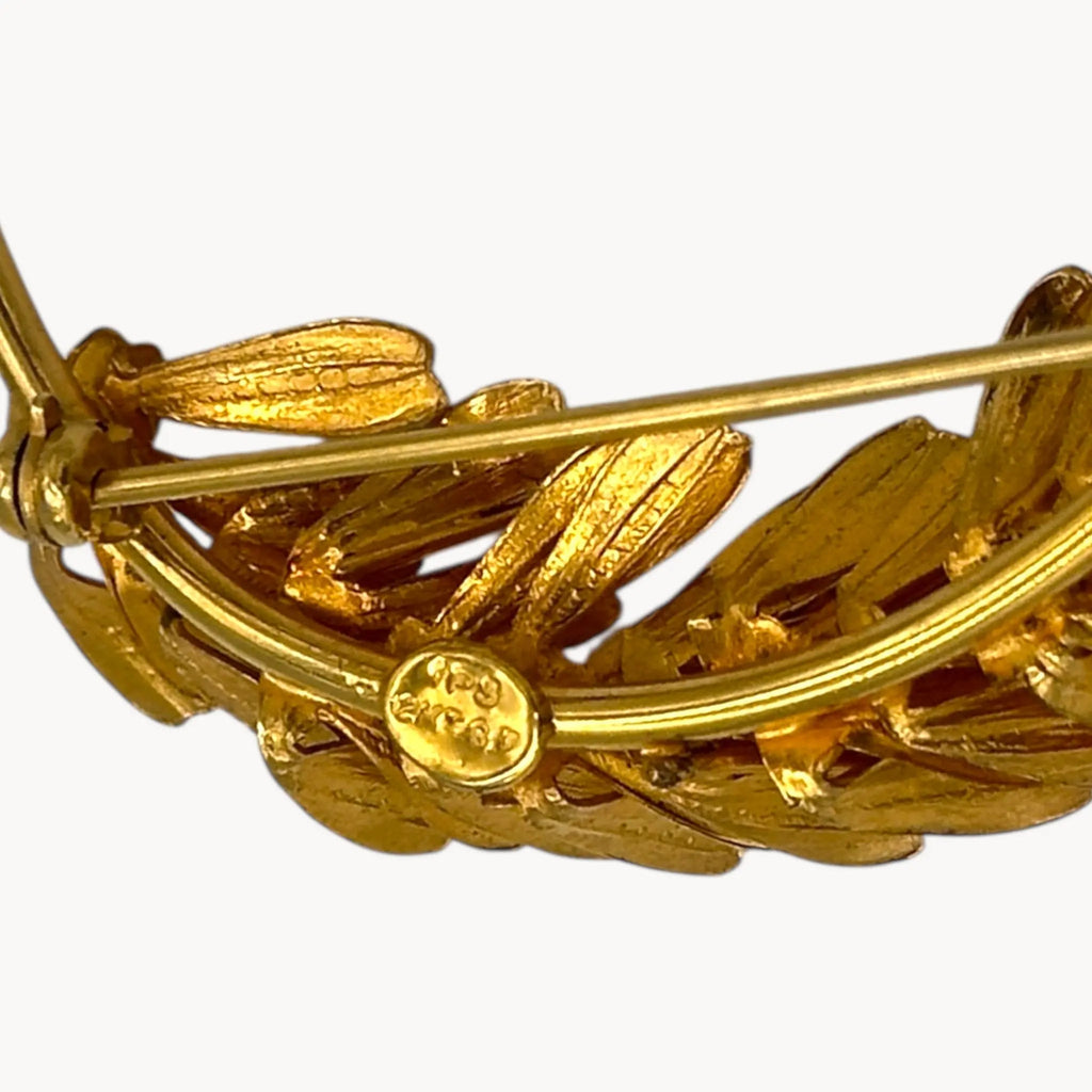 Makers mark of gold filled floral brooch shown on white background.