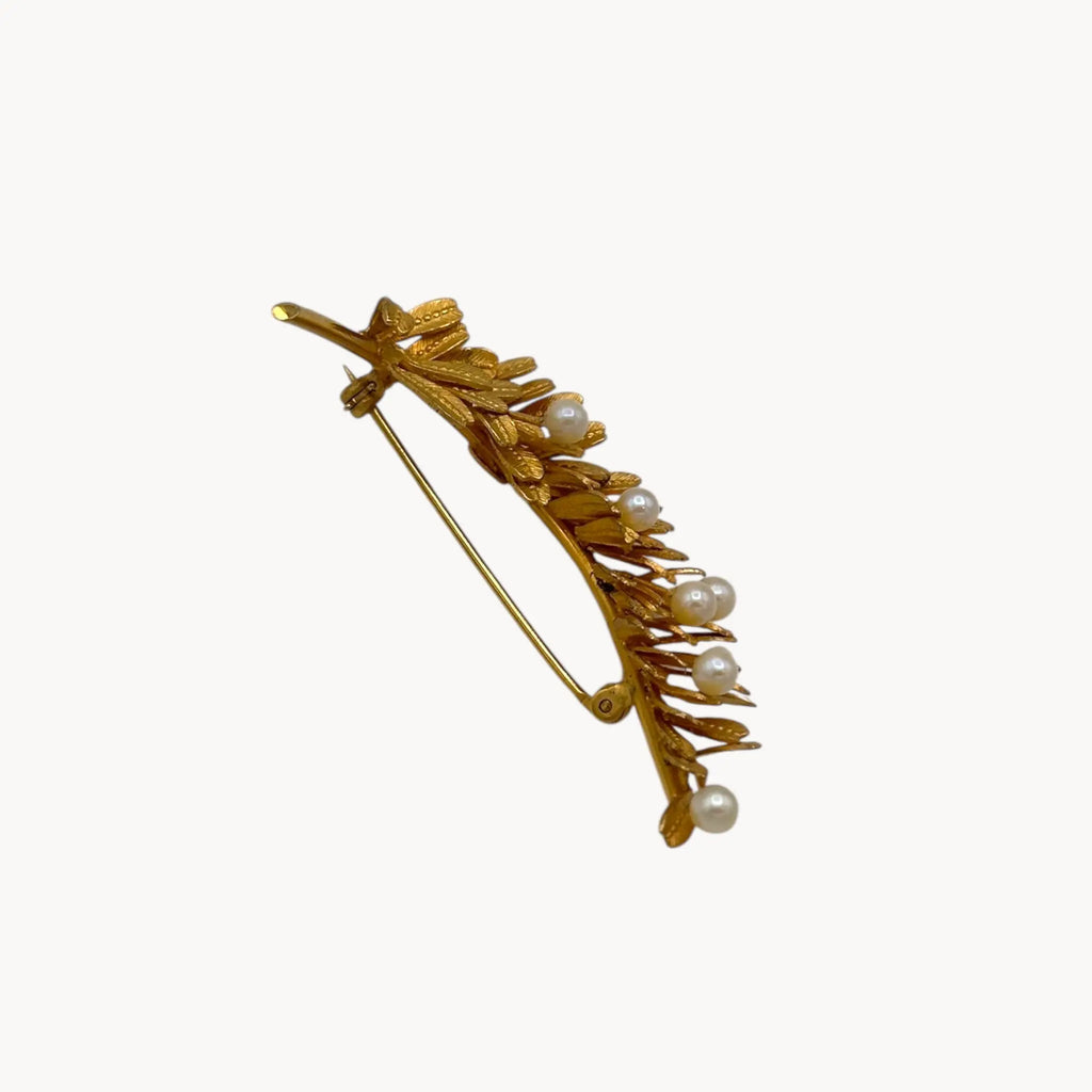 Side view of Vintage gold-filled floral brooch with detailed leaf design and real pearl accents, mid-century shown on white background.