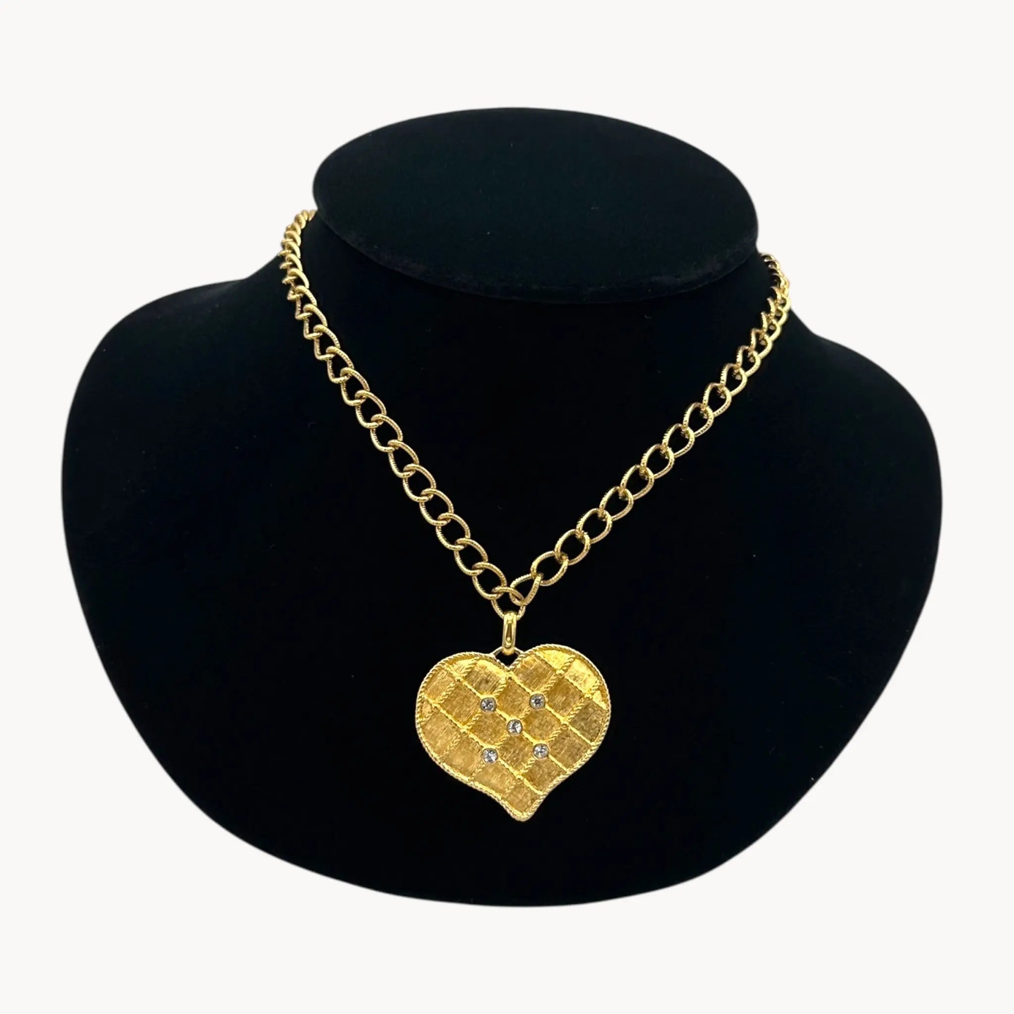 Close up view of Vintage gold heart pendant necklace with rhinestone accents on a chunky chain.