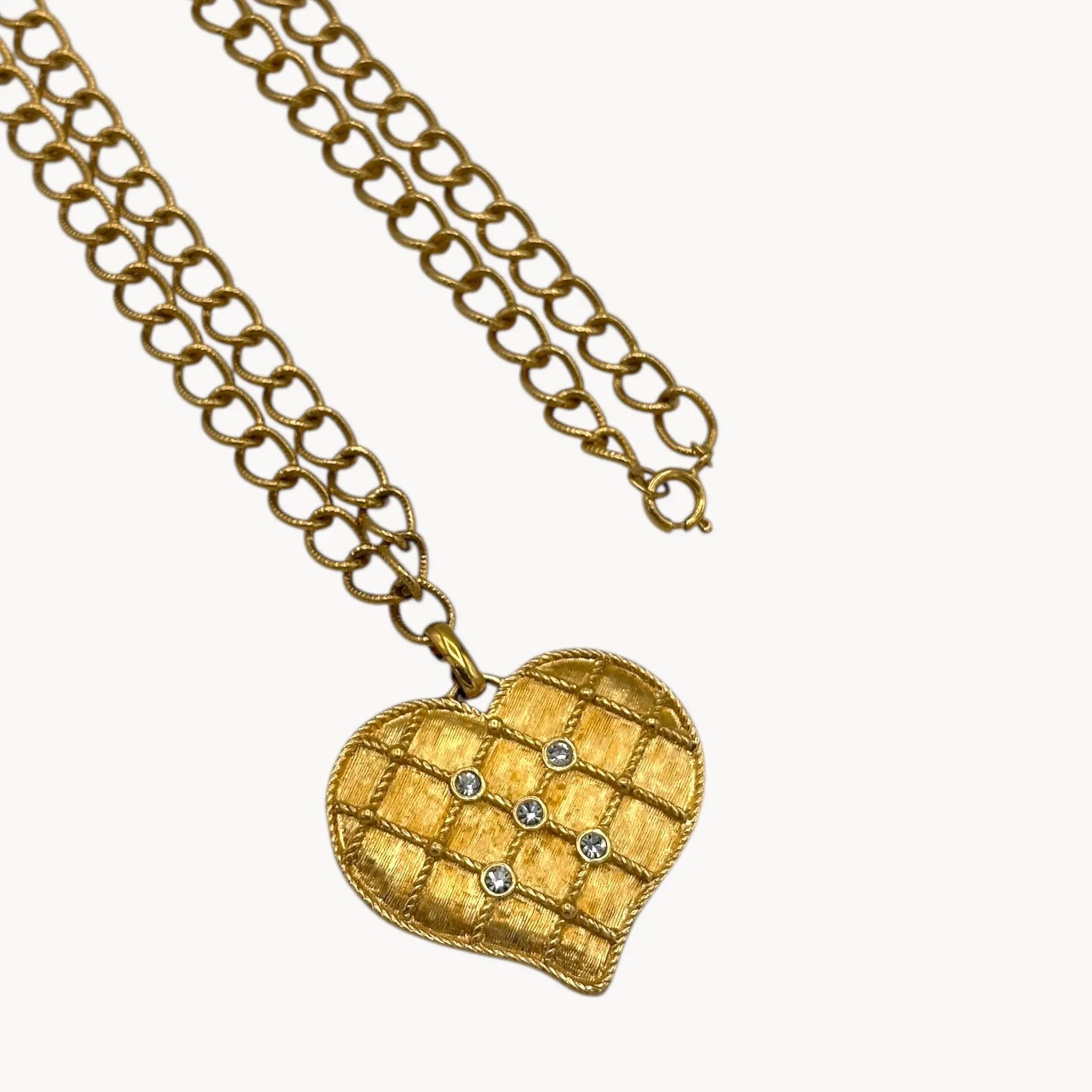 Close up view of pendant of Vintage gold heart pendant necklace with rhinestone accents on a chunky chain.