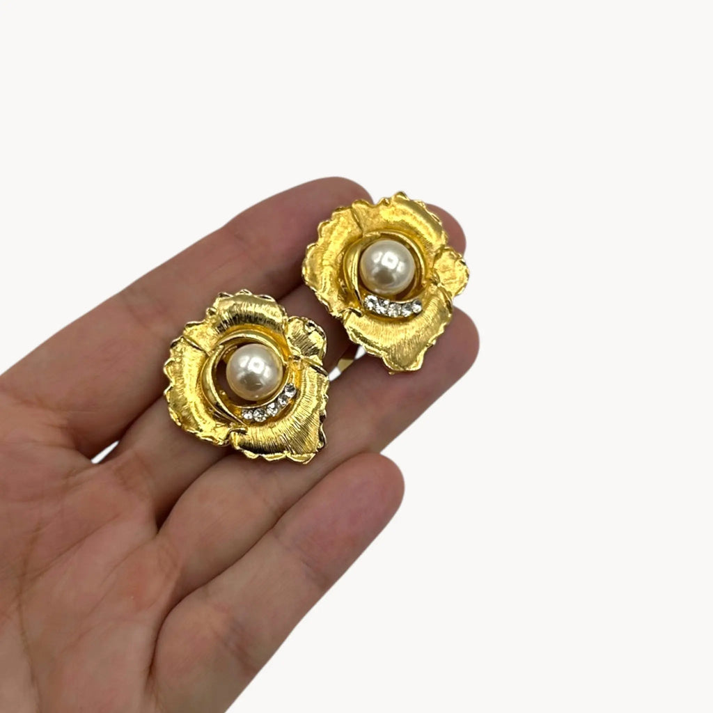 Size picture of Vintage unmarked clip-on earrings with textured gold-tone floral design, faux pearl center, and crystal accents, 1980s bridal jewelry.