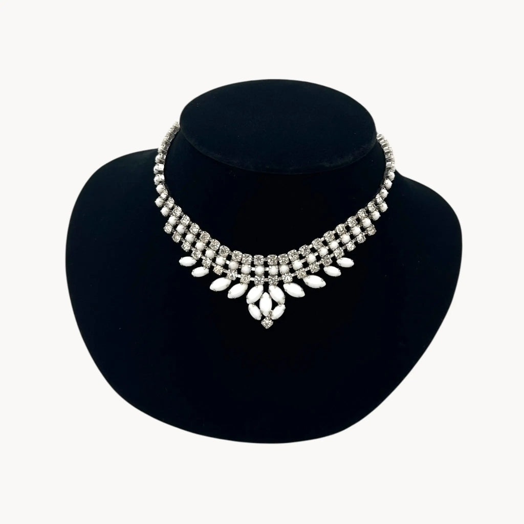 Close up view Vintage Joseph Warner rhinestone necklace with tiered clear crystals and white marquise accents, 1950s–1960s bridal statement jewelry.