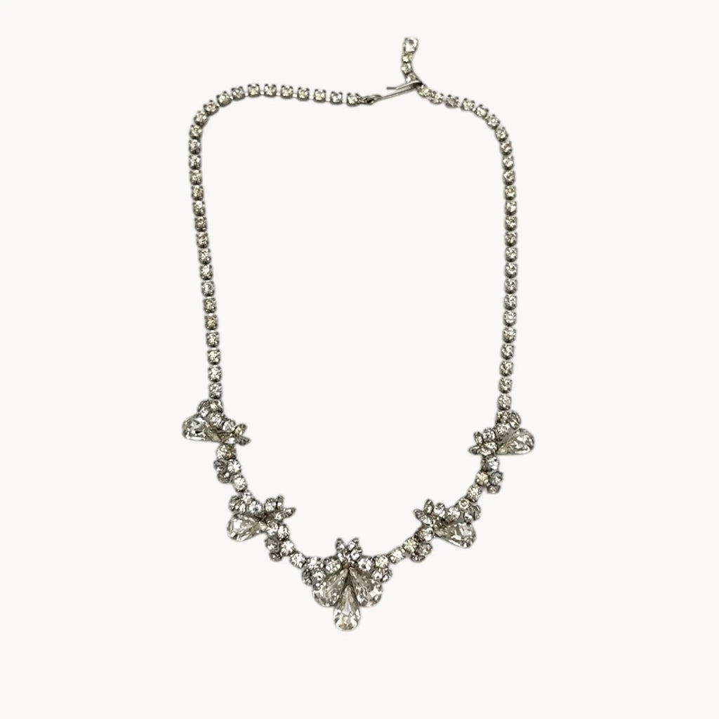 Vintage mid-century teardrop rhinestone necklace with graduated clear crystals on silver setting displayed on white background.