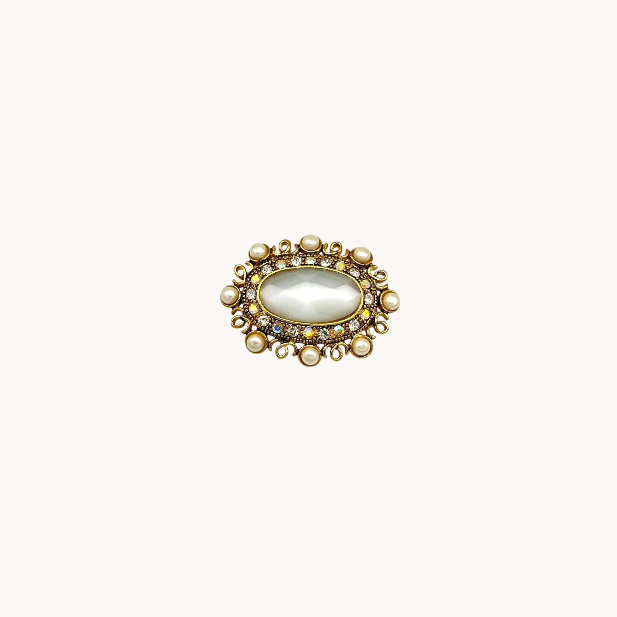 Vintage Monet oval brooch with faceted glass center, faux pearls, and crystal accents.