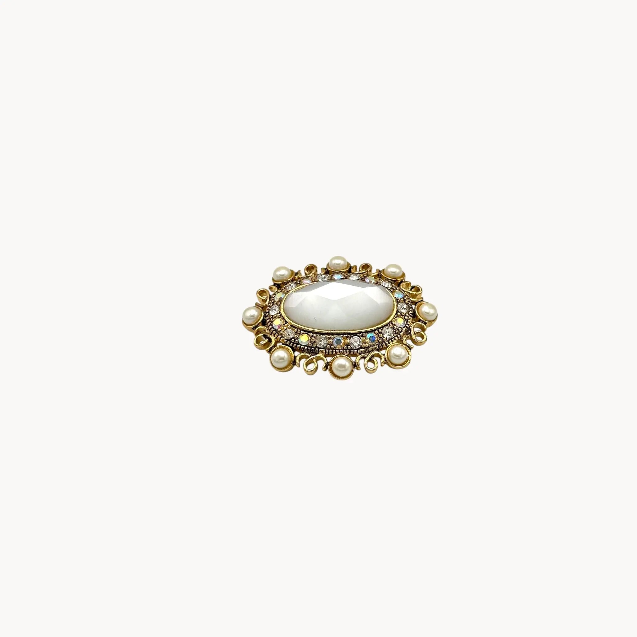 Side view Vintage Monet oval brooch with faceted glass center, faux pearls, and crystal accents.