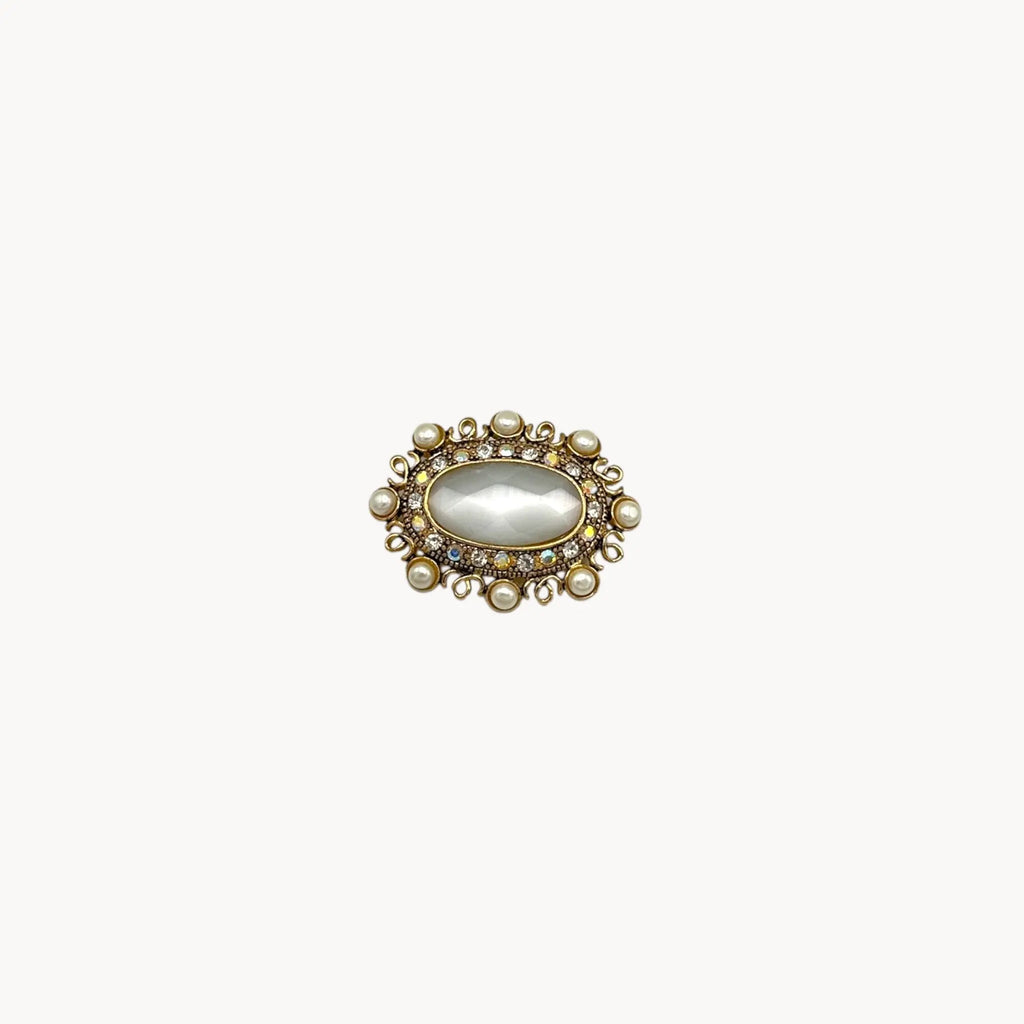 Vintage Monet oval brooch with faceted glass center, faux pearls, and crystal accents.