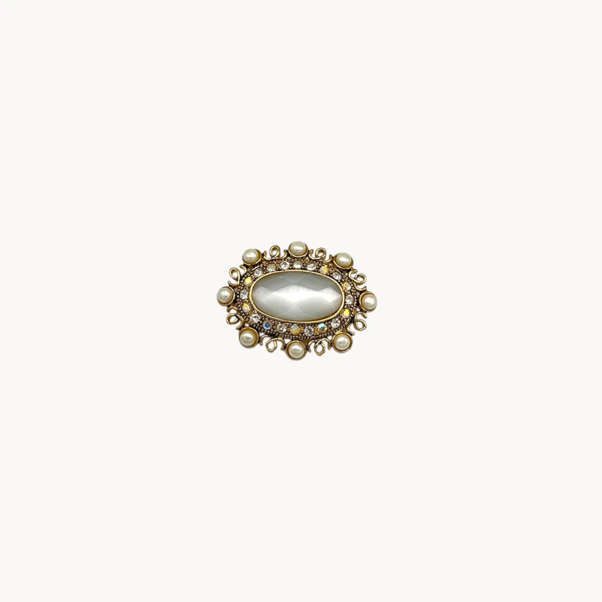 Vintage Monet oval brooch with faceted glass center, faux pearls, and crystal accents.