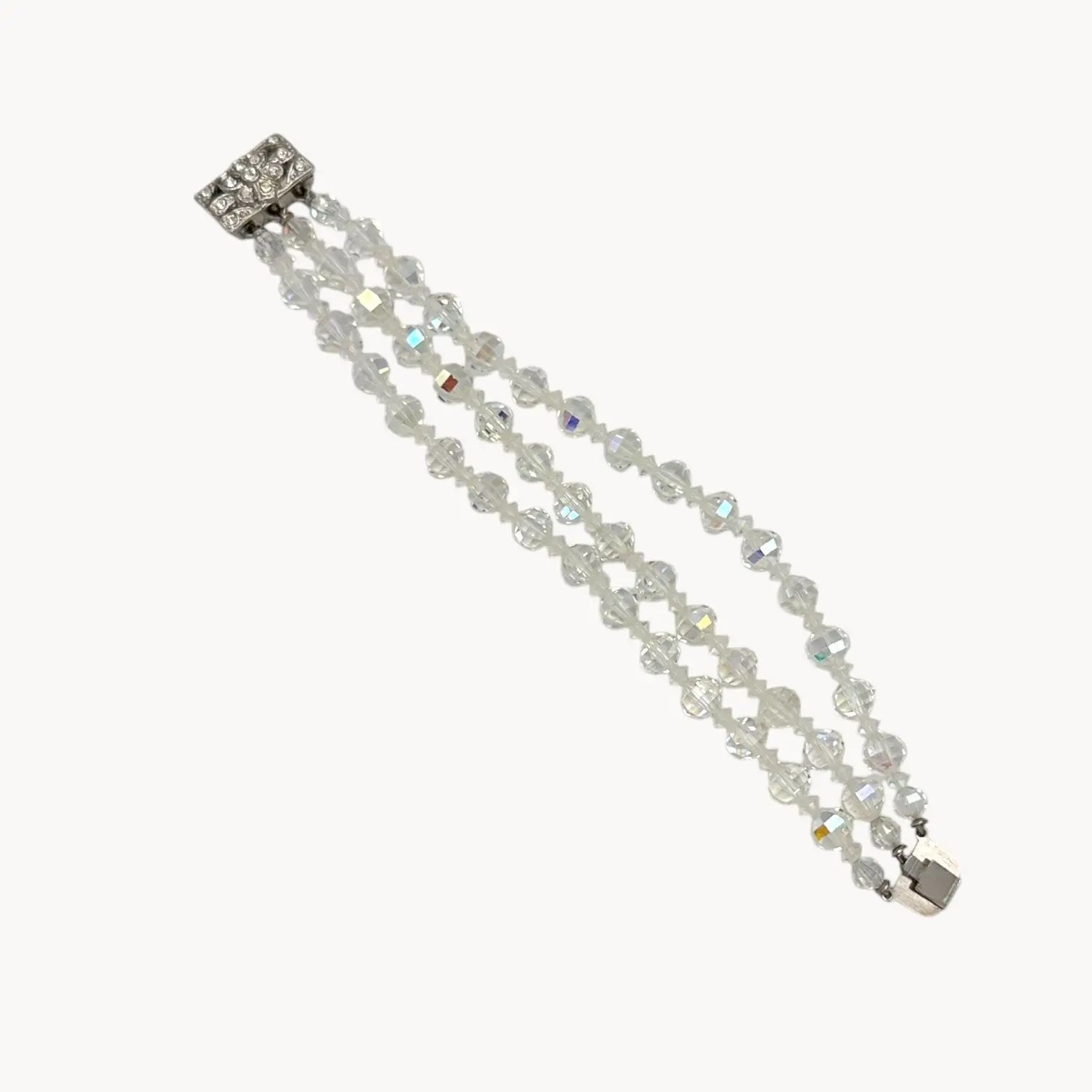 Flat lay of Vintage unsigned multi-strand faceted crystal bracelet with rhinestone clasp in Art Deco style.