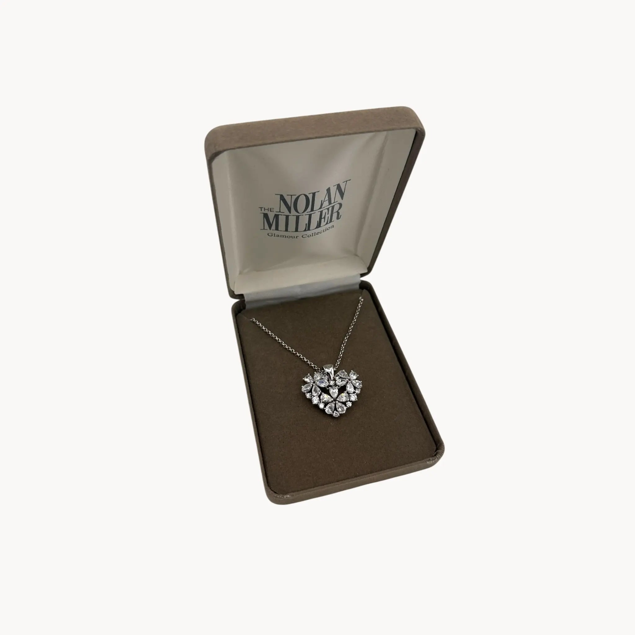 Vintage Nolan Miller rhinestone heart pendant necklace on silver chain in original box.