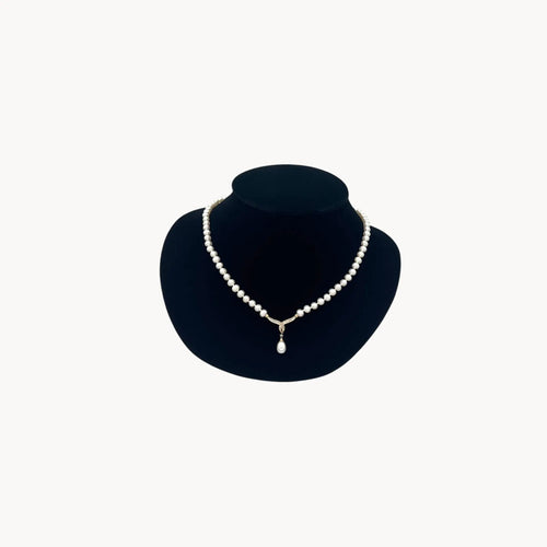 Vintage pearl strand necklace with 10K gold and diamond drop pendant, bridal jewelry on white background.