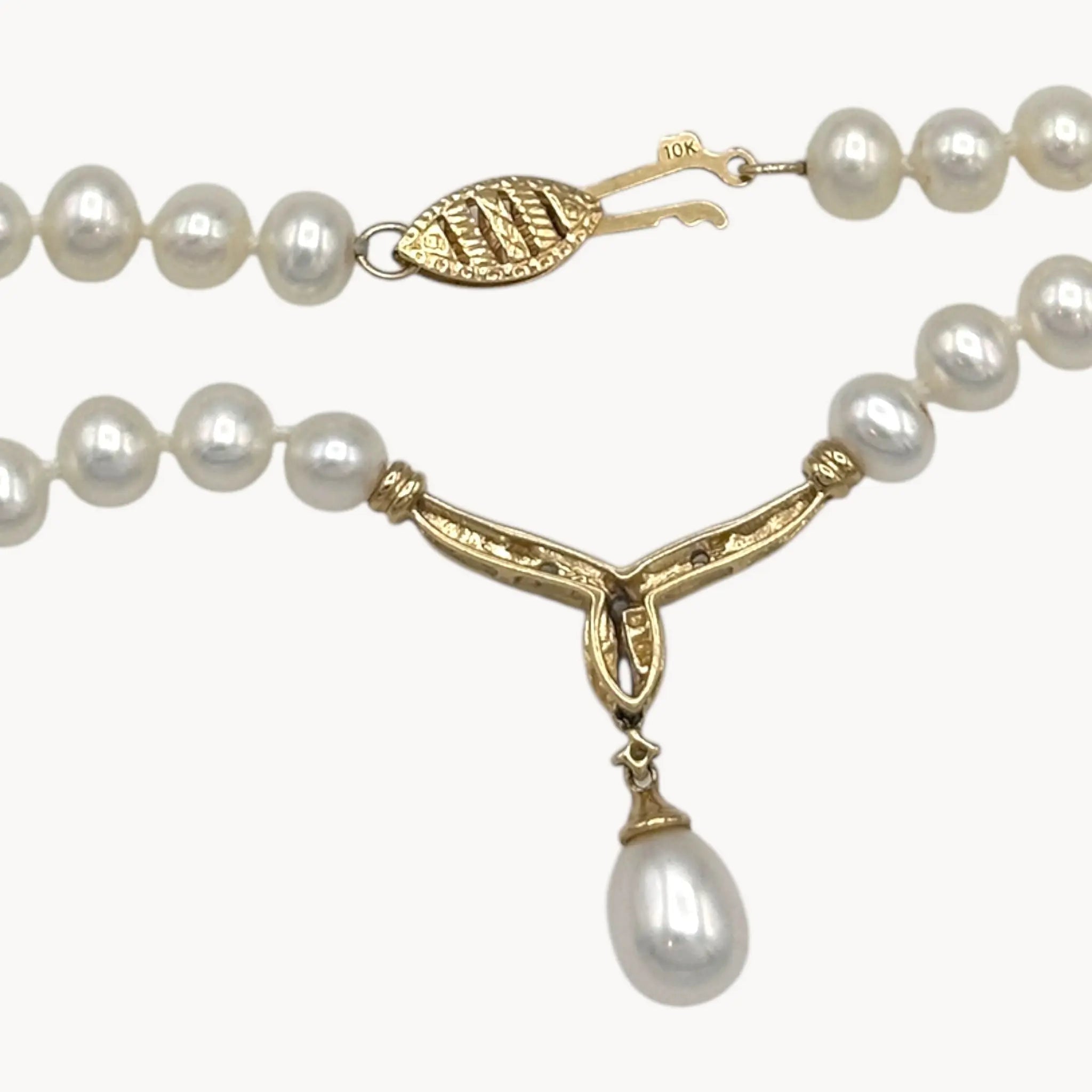 Close up of clasp and pendant back of Vintage pearl strand necklace with 10K gold and diamond drop pendant, bridal jewelry on white background.