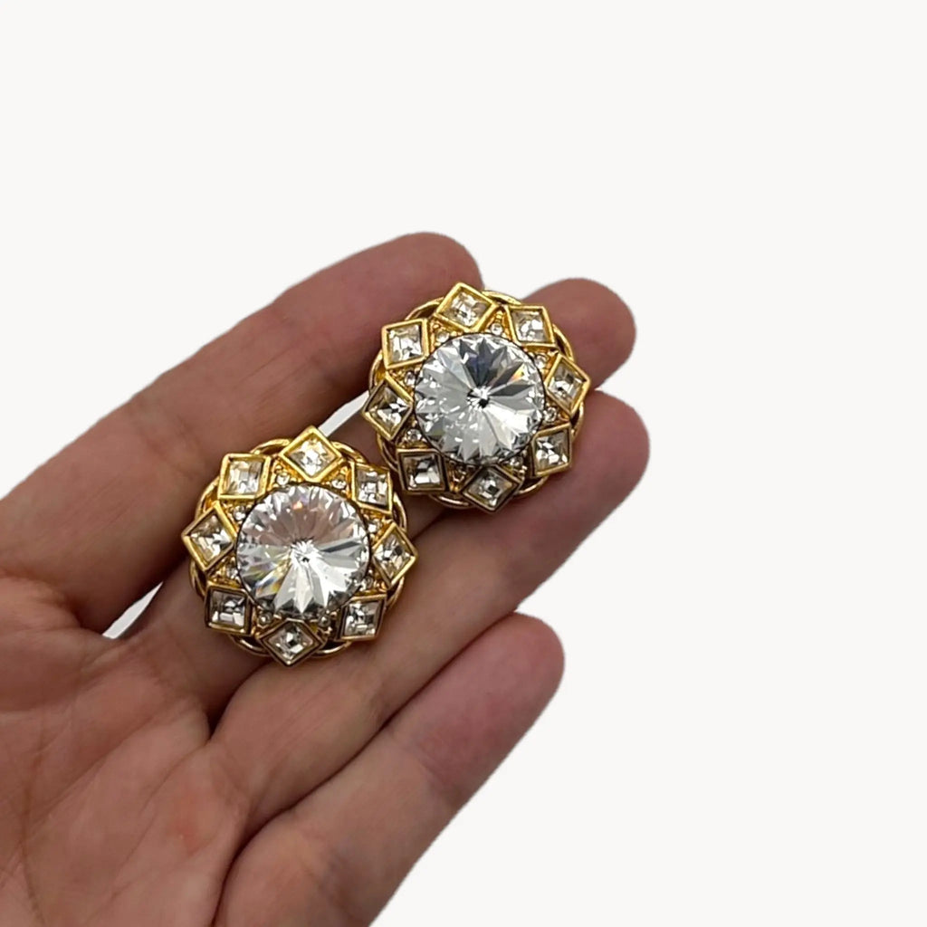 Scale side view on hand of Vintage St. John clip-on earrings with round crystal centers and square-cut crystal frame in gold-tone setting, bridal jewelry.