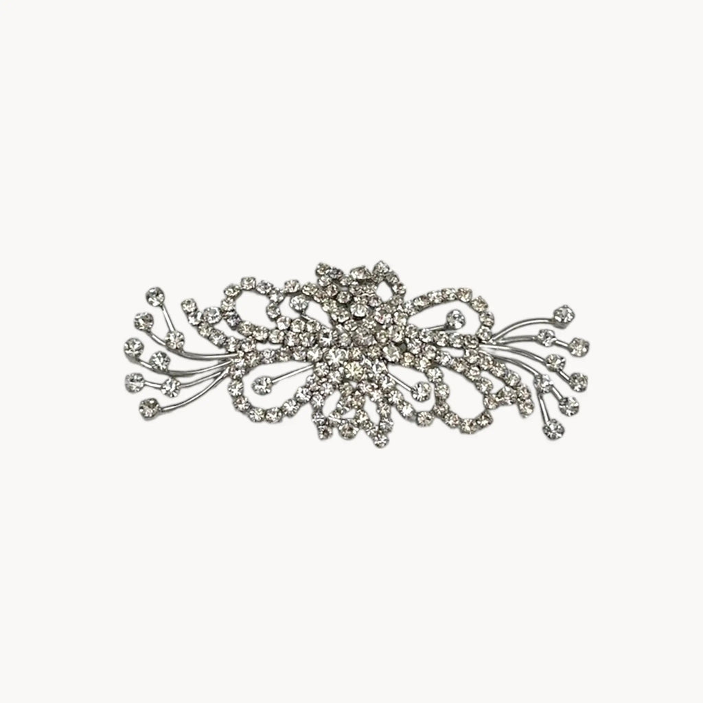 Close up view of Large vintage rhinestone spray brooch with prong-set stones and rhodium plating, mid-century design.