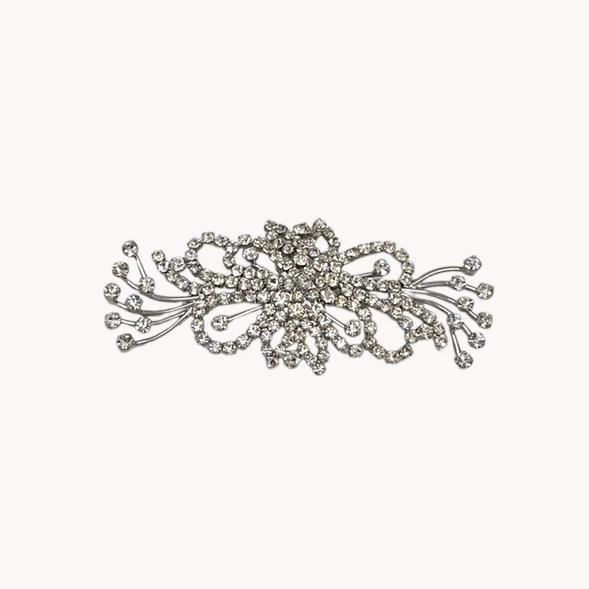 Close up view of Large vintage rhinestone spray brooch with prong-set stones and rhodium plating, mid-century design.