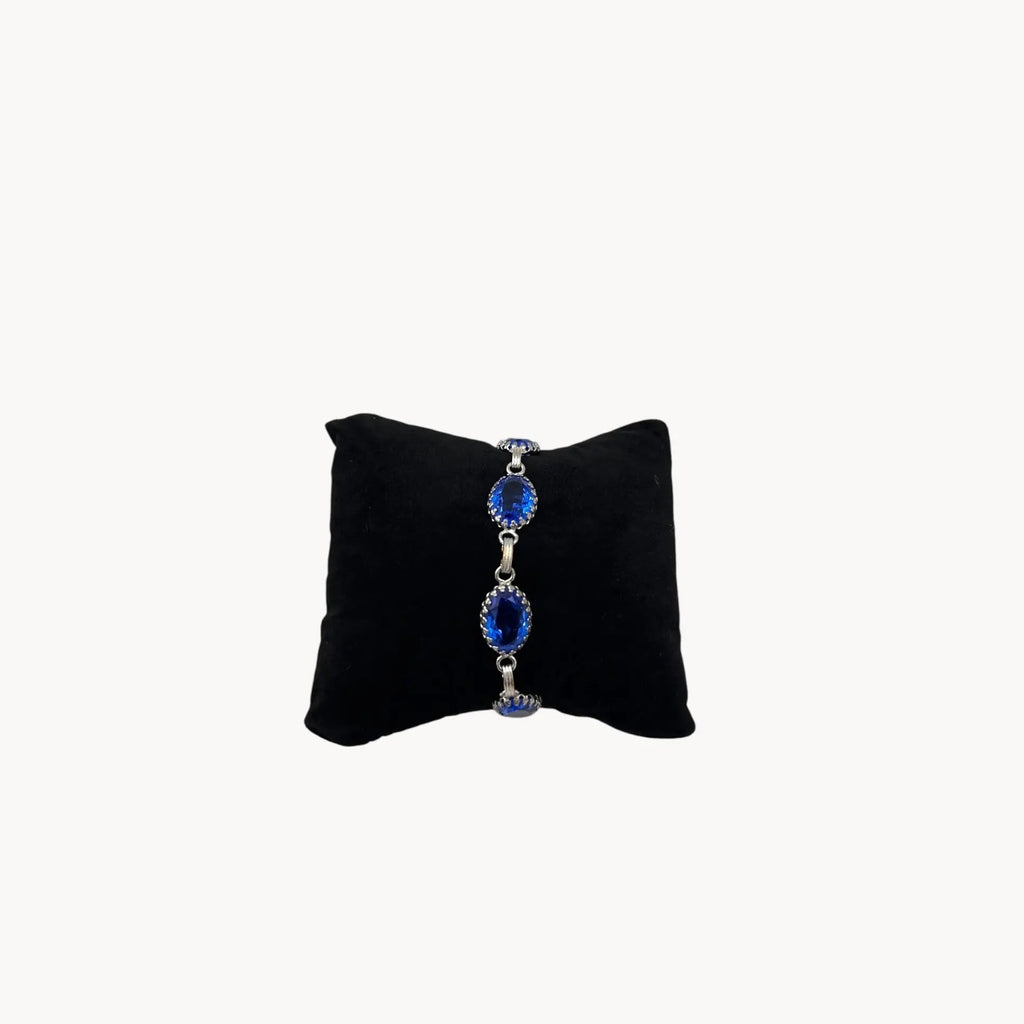 Front view of Vintage sterling silver blue glass link bracelet with oval sapphire-toned stones, mid-century bridal jewelry.
