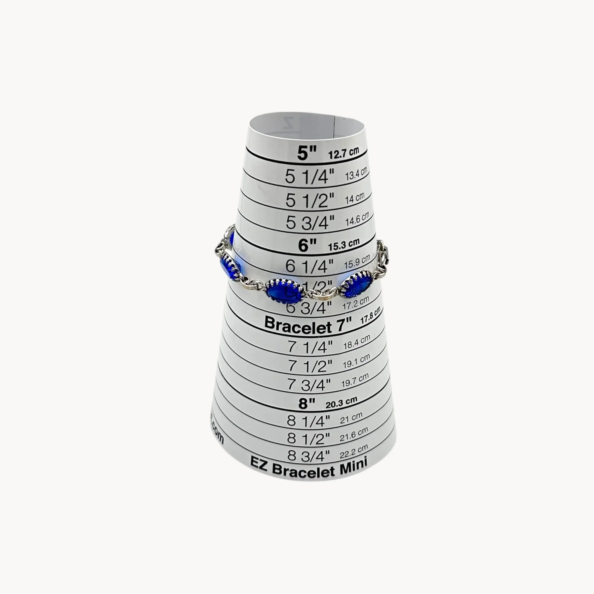 On sizer view of Vintage sterling silver blue glass link bracelet with oval sapphire-toned stones, mid-century bridal jewelry.