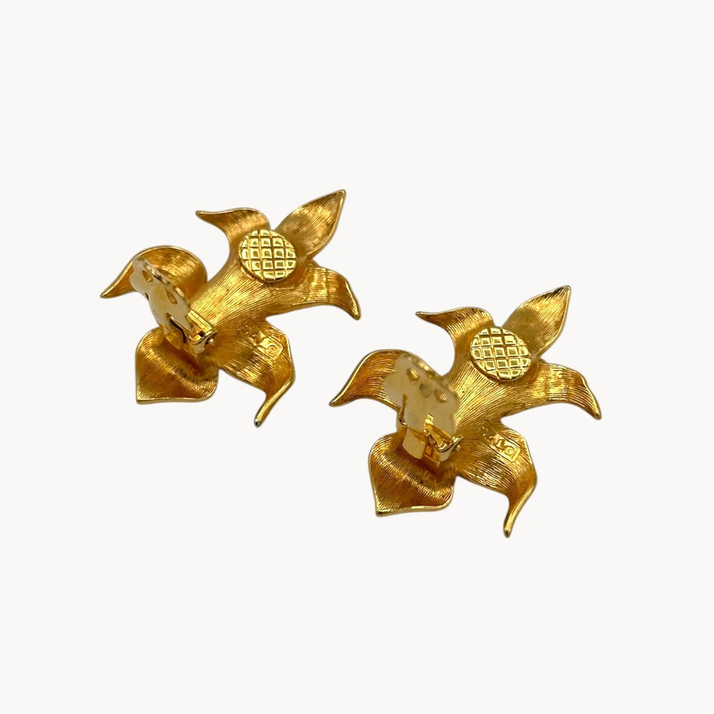 Back view with clips up of Vintage Swarovski SAL floral clip-on earrings with gold-tone petals, faux pearls, and crystal accents, 1980s bridal jewelry on white background.