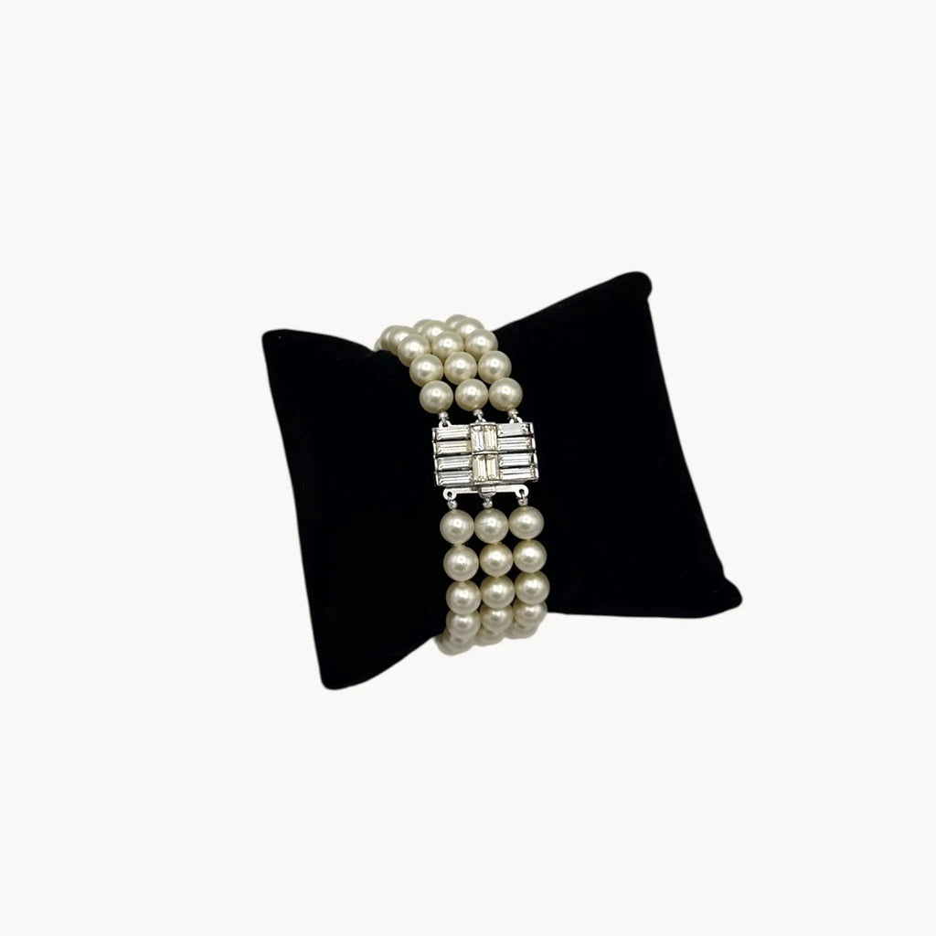 Close up view Vintage Trifari faux pearl triple-strand bracelet with baguette crystal clasp, 1950s–1960s bridal jewelry