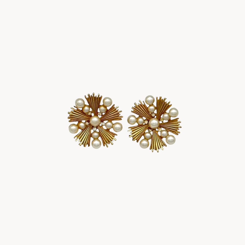 Trifari gold starburst clip-on earrings with faux pearls and rhinestones, 1960s jewelry on white background.