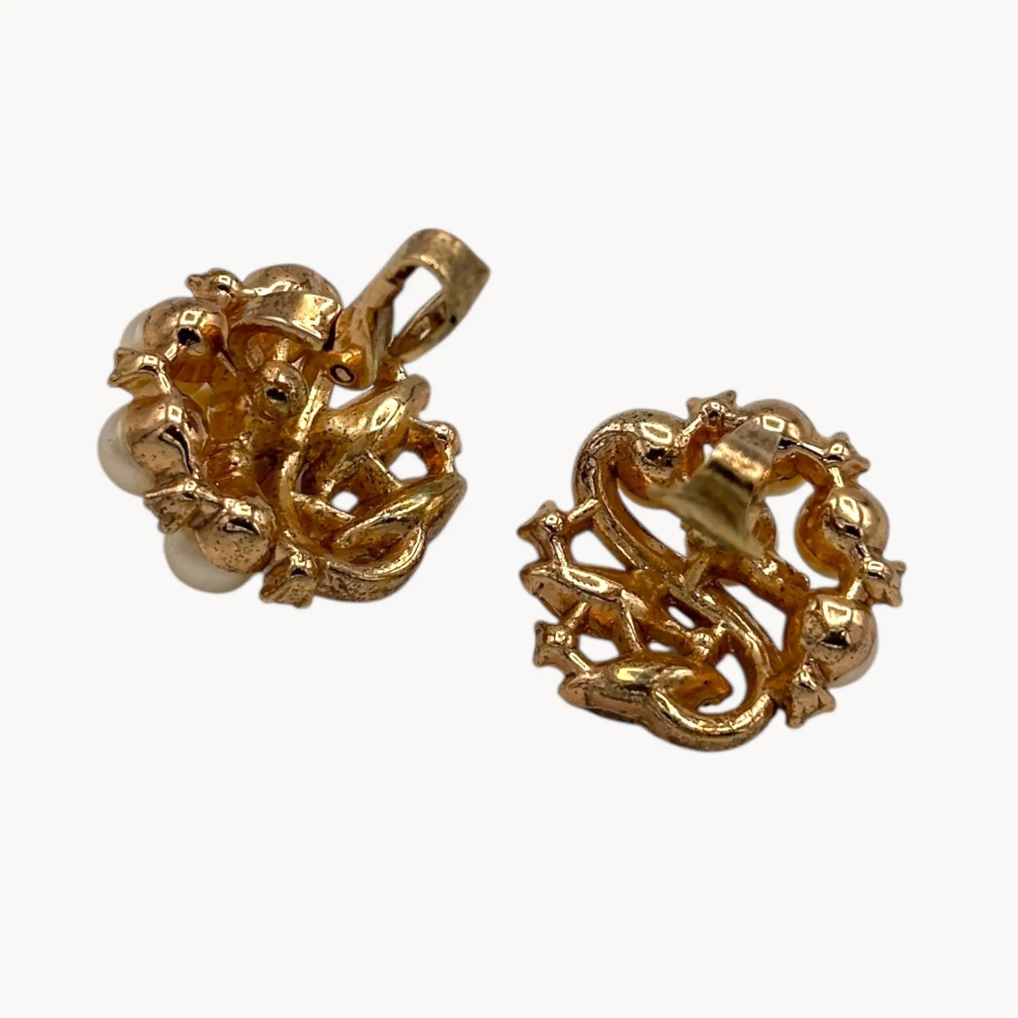 Clips up on earrings of Brooch of the Vintage Trifari brooch with faux pearls, rhinestones, and gold-tone design shown on white background.