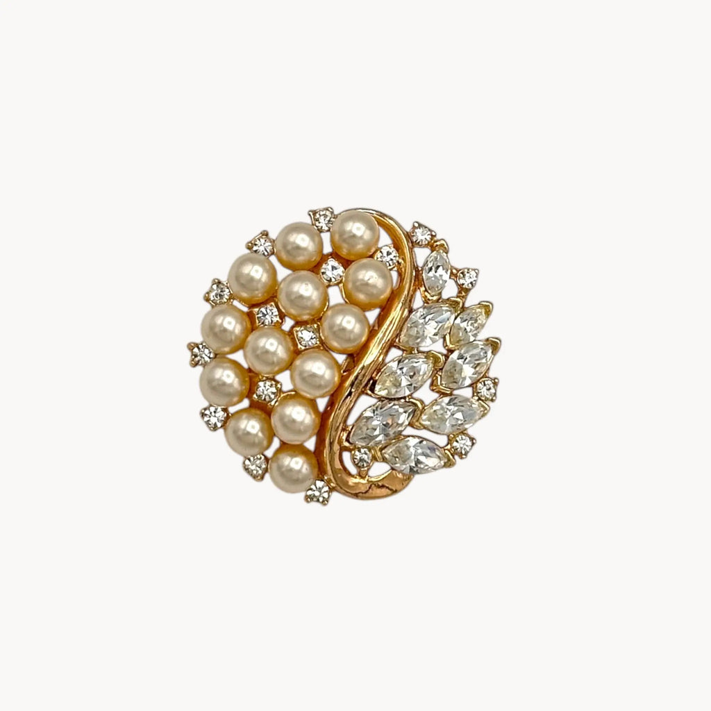 Brooch of the Vintage Trifari brooch with faux pearls, rhinestones, and gold-tone design shown on white background.