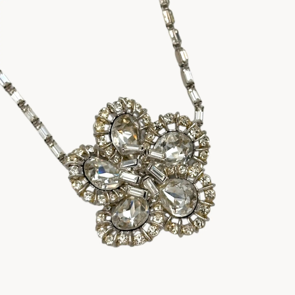 Close up view of Large Trifari Rhinestone Floral Necklace on white background.