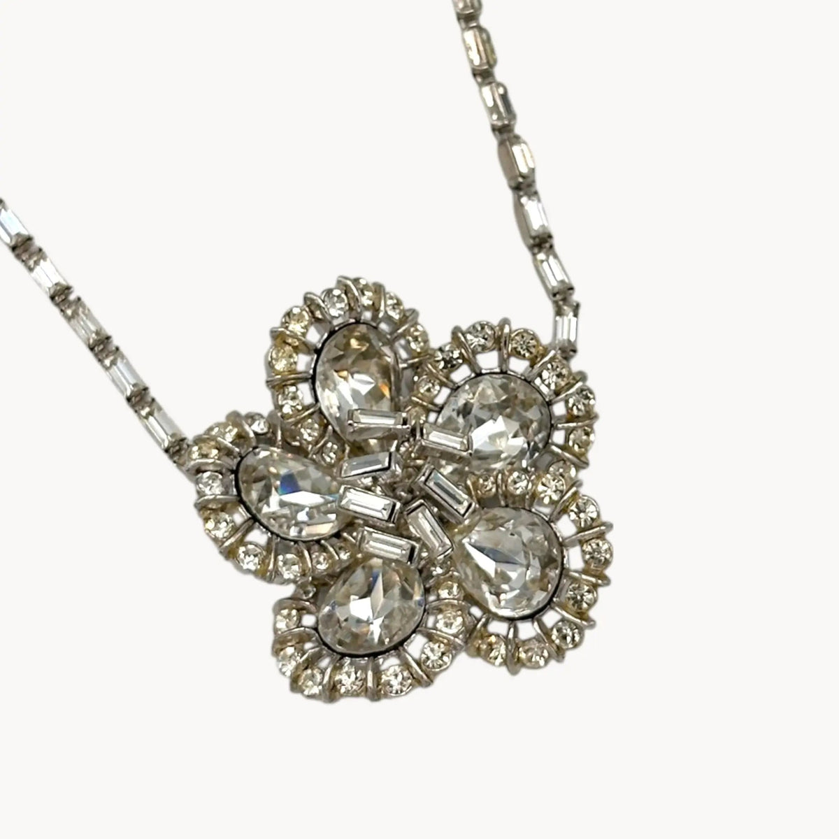Close up view of Large Trifari Rhinestone Floral Necklace on white background.