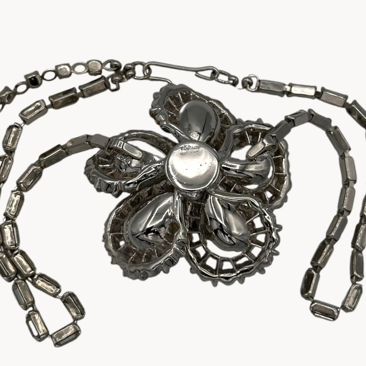 Back view of Large Trifari Rhinestone Floral Necklace on white background.