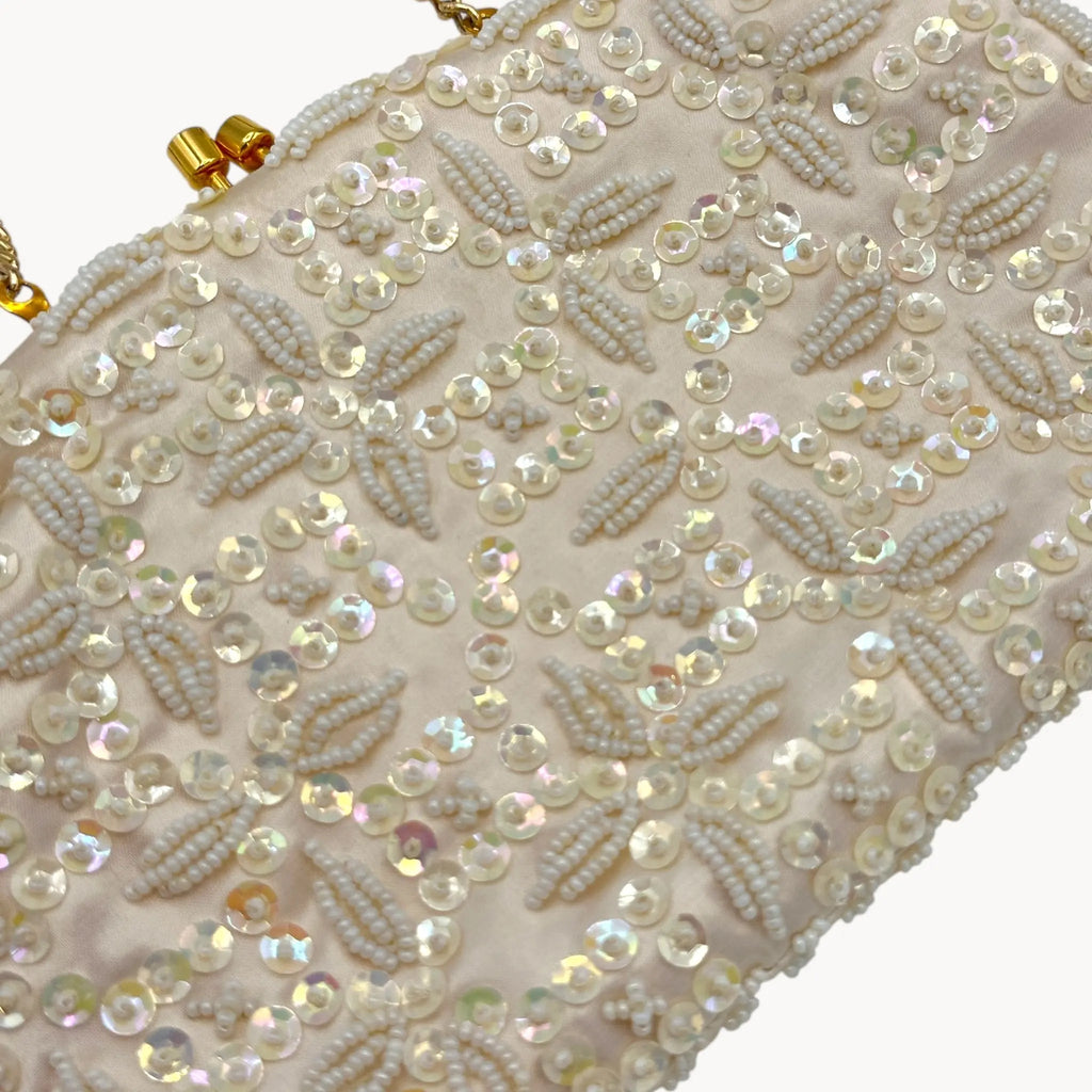 Close up view of Vintage white sequined beaded handbag with gold chain handle and kiss-lock clasp